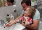 Zuzia u taty na kolanach, myją ręce